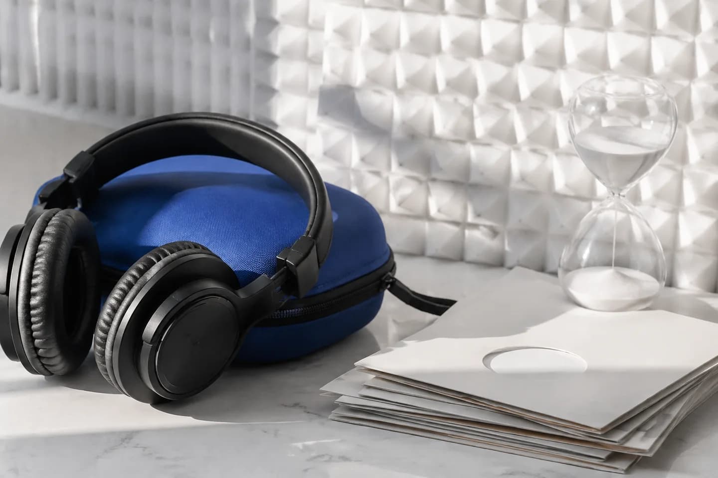 Headphones, session sleeves, and an hourglass representing editing workload.