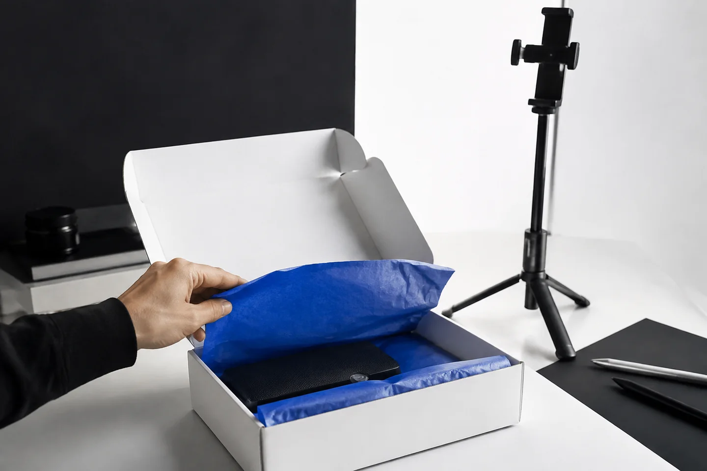 Hands preparing a product unboxing for a launch recording.