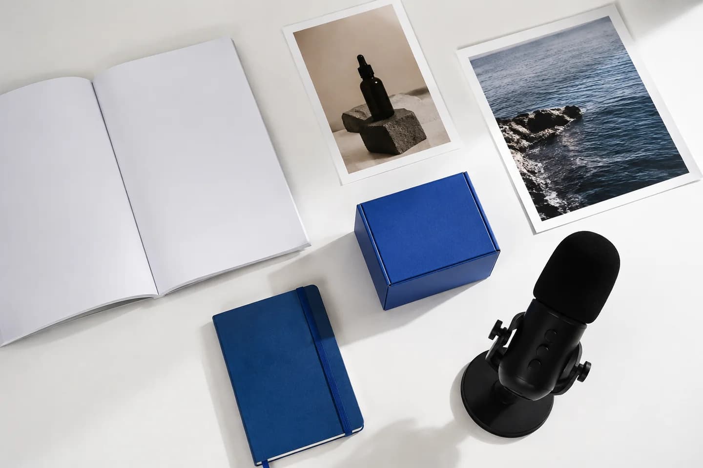 A blank brochure, photographs and recording tools form a marketing kit.