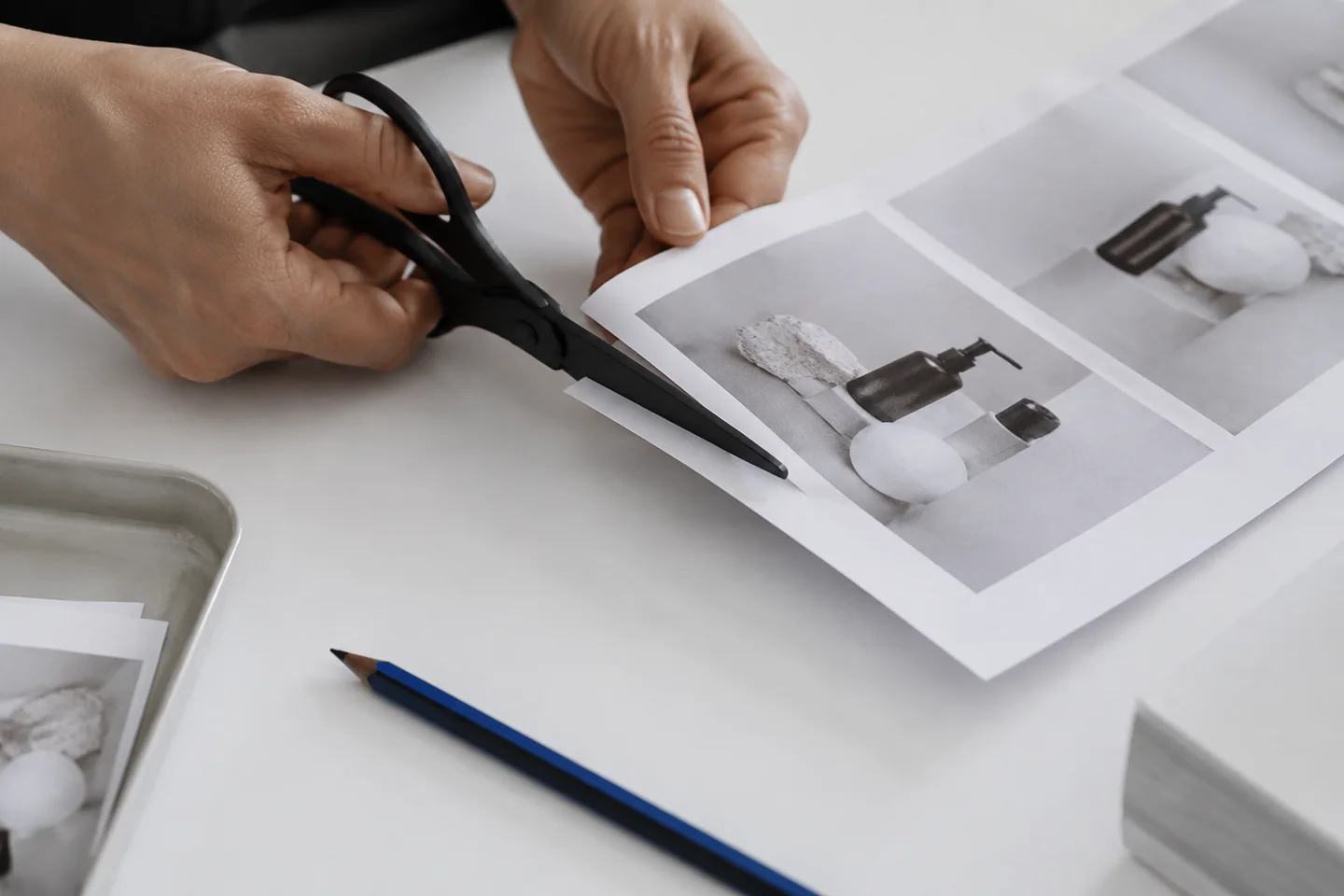 Hands trimming a product-photo sequence with scissors.