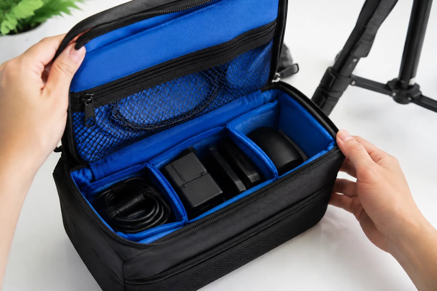 Hands showing an organizer pouch's compartments during a product video.