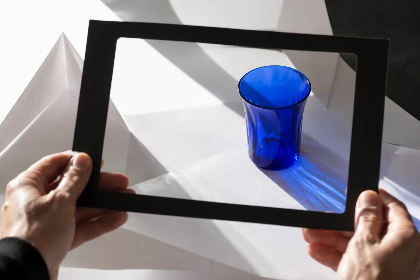 A director framing a blue-glass still life to test creative control.