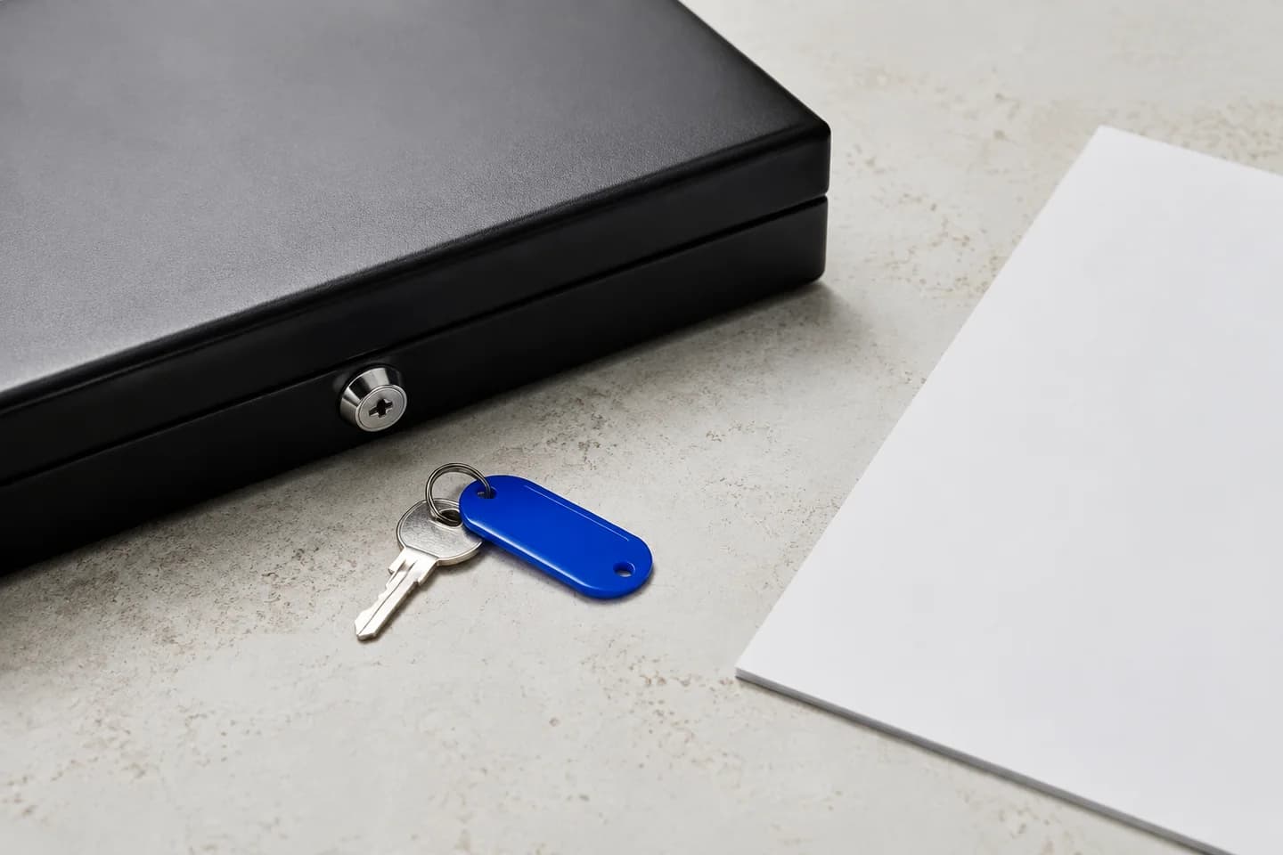 Locked document case with a blue-tagged key on a light tabletop.