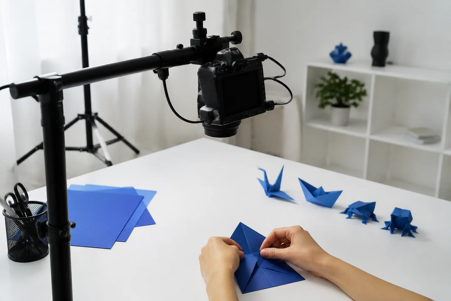 An overhead camera recording a hands-only paper-folding demonstration.