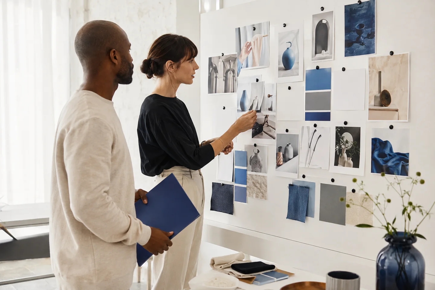 Two marketers planning a campaign with photographs and color swatches.