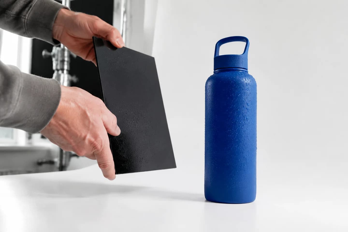 A blue water bottle being lit for a product advertisement.