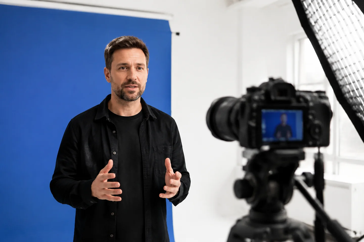 A presenter rehearsing a video segment in a white studio.