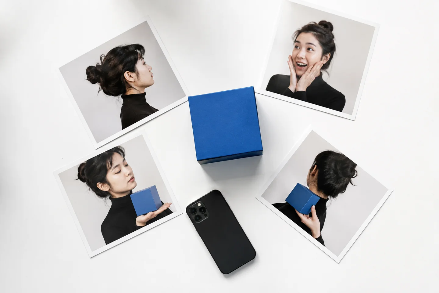 Printed reaction portraits arranged around a blue product box and phone.