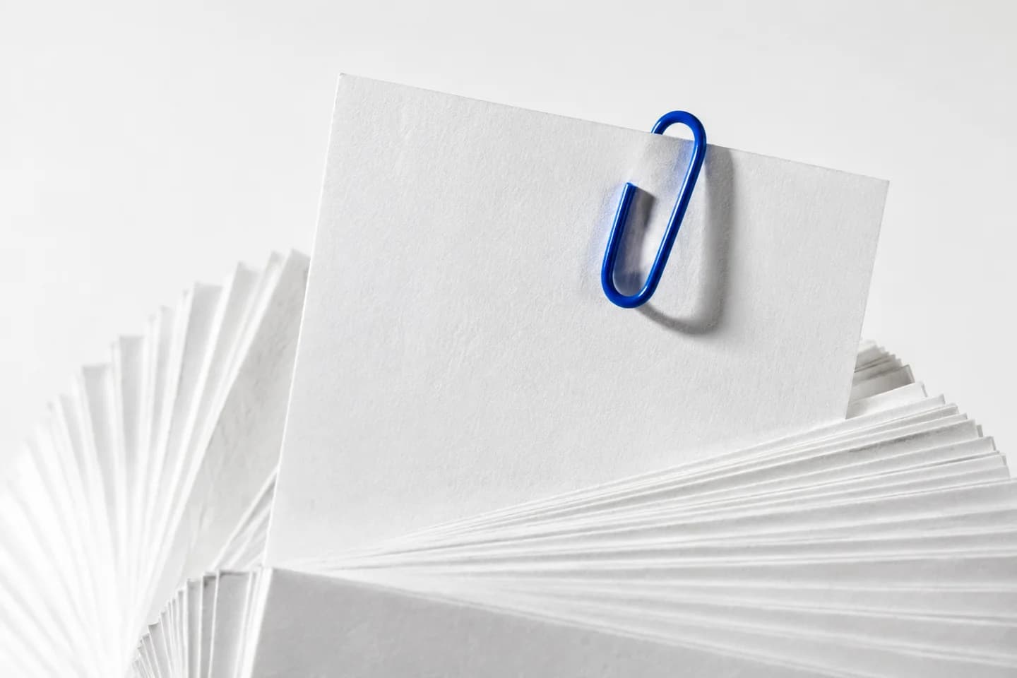 A blue paperclip marks one blank card pulled forward from a stack.